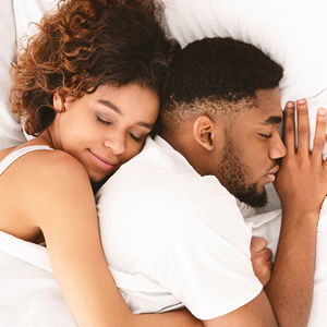 A happy couple sleeping on an electric blanket 